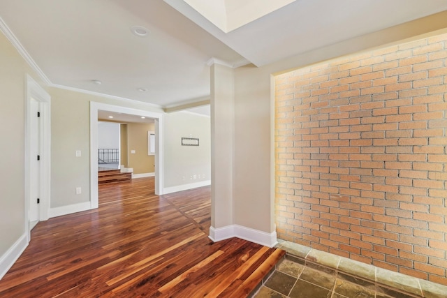 corridor with baseboards, brick wall, dark wood finished floors, and ornamental molding