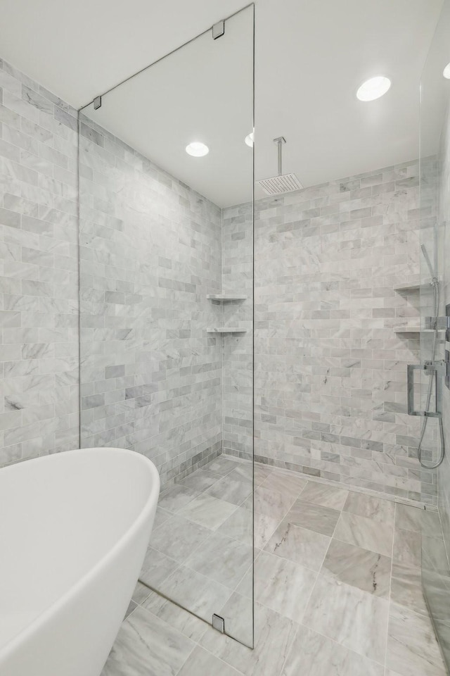 full bathroom featuring a freestanding tub, tile walls, and a walk in shower