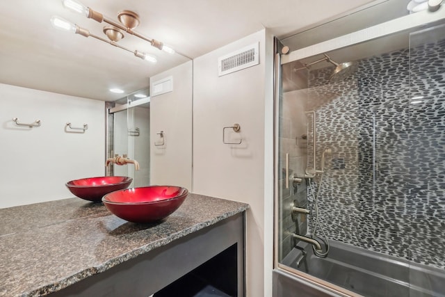 bathroom with visible vents, vanity, and shower / bath combination with glass door