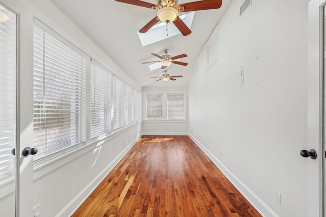 unfurnished sunroom with lofted ceiling with skylight and visible vents