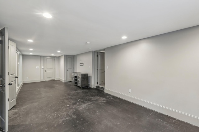 unfurnished room with recessed lighting, concrete flooring, and baseboards