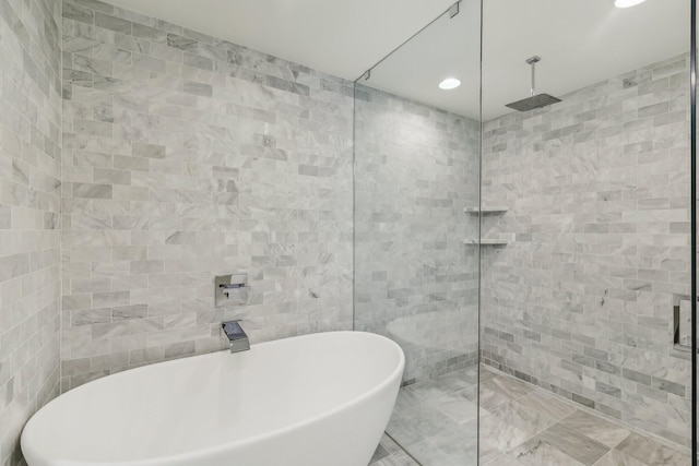 full bath featuring tile walls, a freestanding tub, recessed lighting, and a tile shower