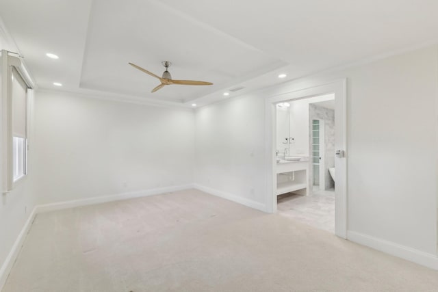 unfurnished room with a tray ceiling, recessed lighting, baseboards, and light carpet