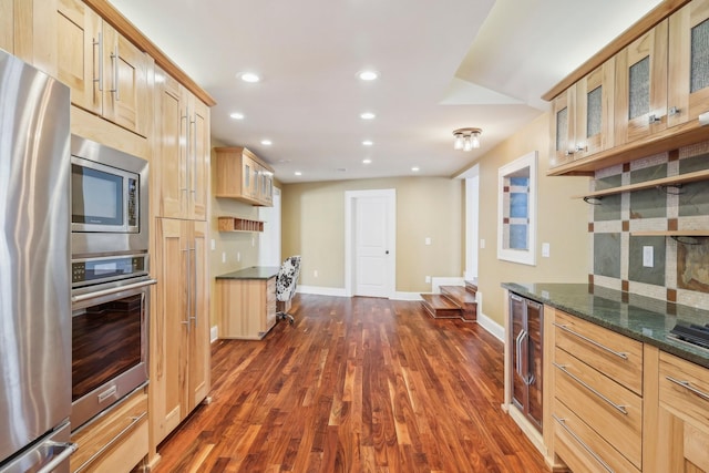 kitchen with glass insert cabinets, light brown cabinetry, recessed lighting, appliances with stainless steel finishes, and dark wood-style floors