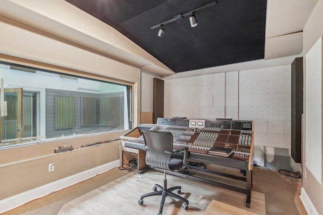 office space with vaulted ceiling, rail lighting, and baseboards