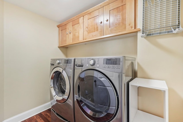 washroom with baseboards, cabinet space, dark wood-style flooring, and washing machine and clothes dryer