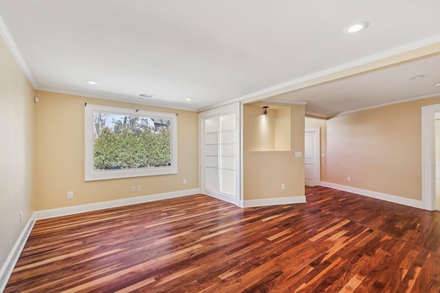 spare room with baseboards, wood finished floors, and crown molding