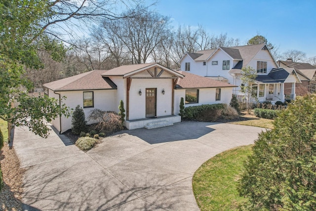 view of front of house with brick siding, roof with shingles, and concrete driveway