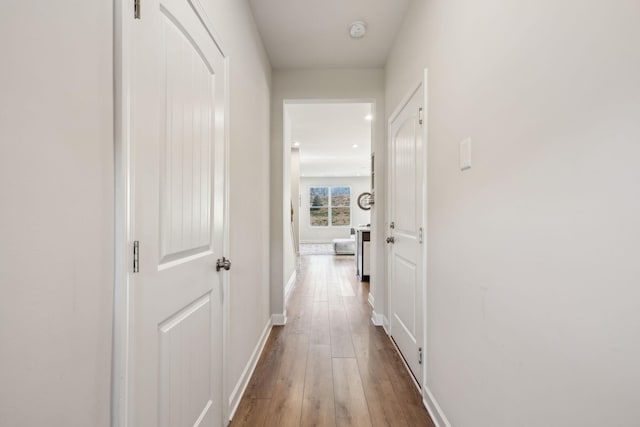 hallway featuring baseboards and wood finished floors