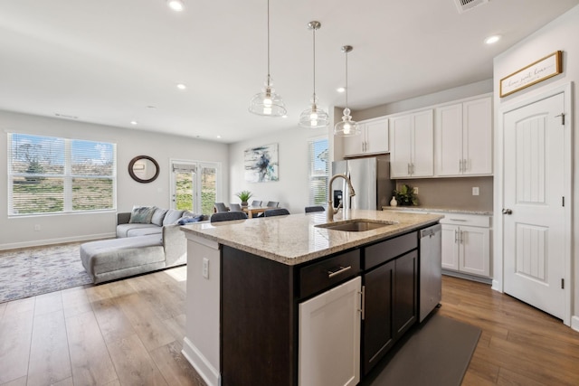 kitchen featuring a sink, stainless steel appliances, light wood-type flooring, and white cabinets