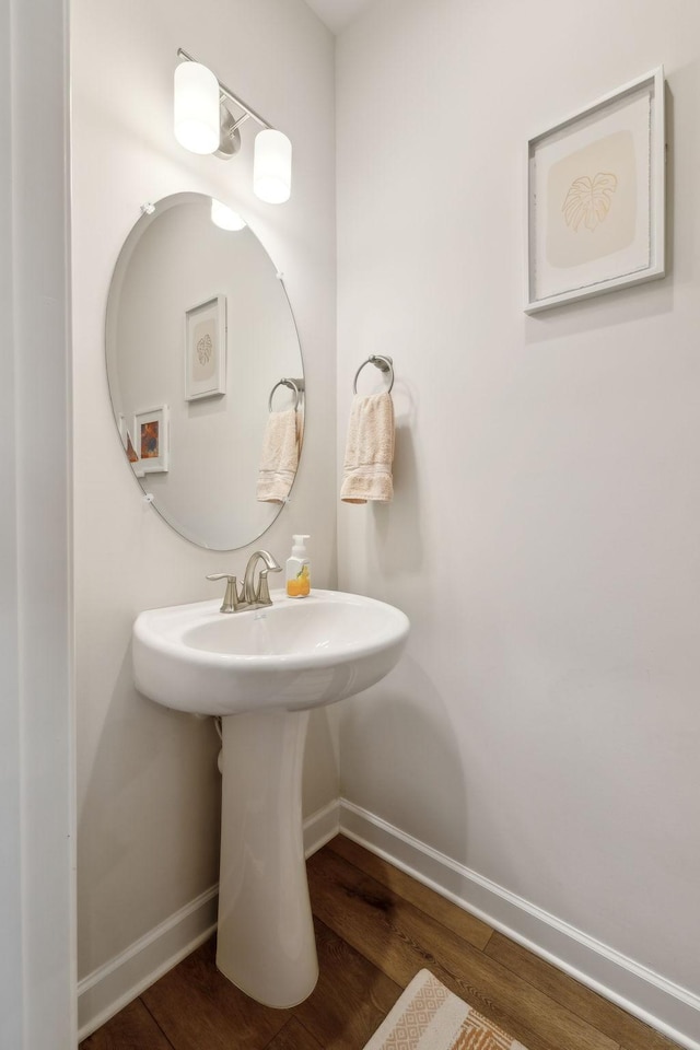 bathroom featuring a sink, baseboards, and wood finished floors