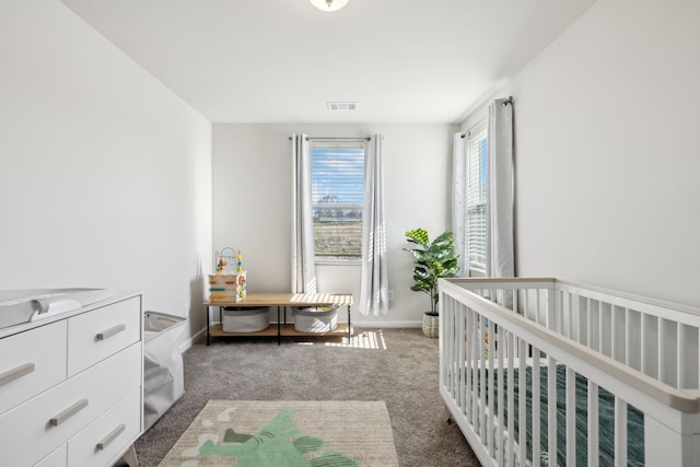 carpeted bedroom featuring a nursery area, baseboards, visible vents, and a sink