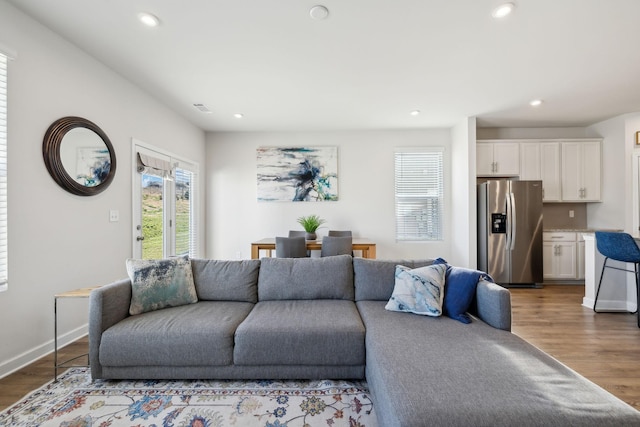 living area featuring recessed lighting, baseboards, and wood finished floors