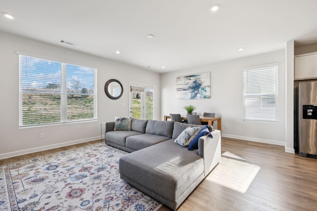 living room featuring recessed lighting, visible vents, light wood finished floors, and baseboards