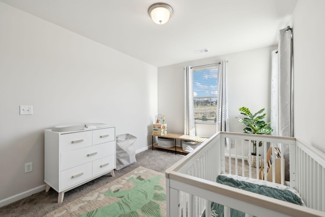 bedroom with a nursery area, baseboards, visible vents, and light carpet