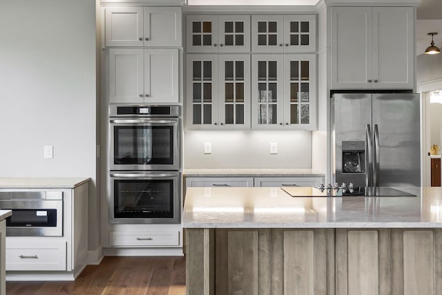 1036 Hidden River Rd, Rock Island, TN 38581 - kitchen with appliances with stainless steel finishes, dark wood finished floors, light stone countertops, and glass insert cabinets