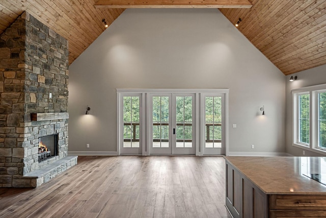 1036 Hidden River Rd, Rock Island, TN 38581 - unfurnished living room featuring high vaulted ceiling, wood finished floors, baseboards, a stone fireplace, and wooden ceiling