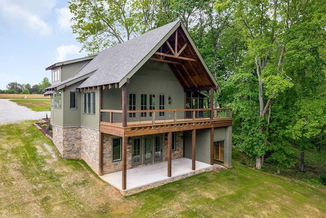 1036 Hidden River Rd, Rock Island, TN 38581 - rear view of property featuring stone siding, a lawn, a patio area, roof with shingles, and a deck