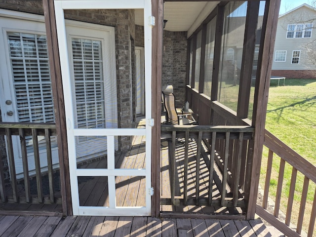 wooden deck featuring a yard and a trampoline