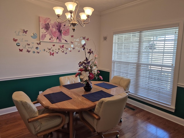 dining area with a chandelier, crown molding, baseboards, and wood finished floors