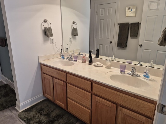 bathroom featuring tile patterned floors, double vanity, baseboards, and a sink