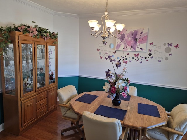 dining room featuring an inviting chandelier, dark wood-style floors, and ornamental molding