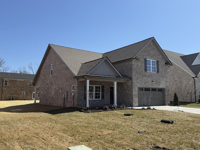 traditional-style home with a garage, brick siding, concrete driveway, and a front lawn