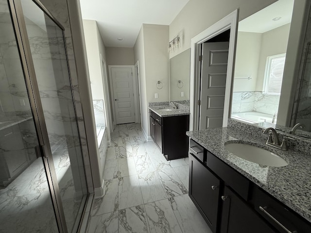 bathroom with a garden tub, marble finish floor, a marble finish shower, and a sink