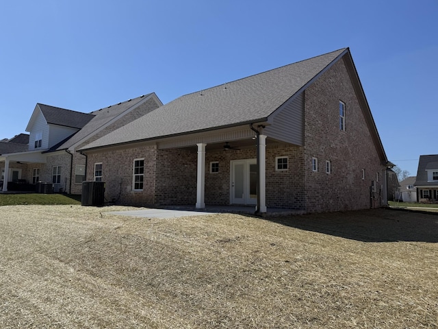 back of property with a patio, ceiling fan, french doors, central air condition unit, and brick siding