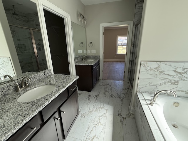 full bath featuring a sink, a garden tub, marble finish floor, and a stall shower