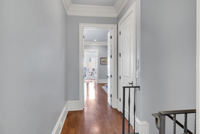 hallway with crown molding, baseboards, and wood finished floors