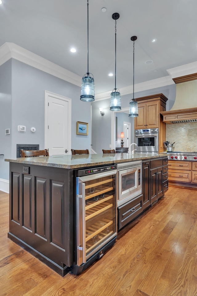 kitchen with backsplash, wine cooler, ornamental molding, appliances with stainless steel finishes, and light wood-style floors