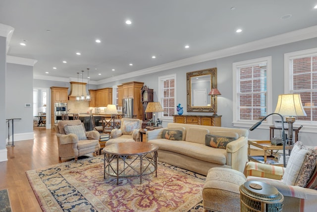 living room featuring recessed lighting, light wood-type flooring, and crown molding