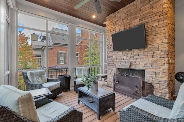 sunroom / solarium with wood ceiling, ceiling fan, and a fireplace