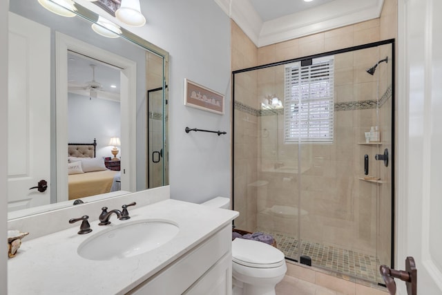 ensuite bathroom with ceiling fan, toilet, vanity, a stall shower, and ensuite bath