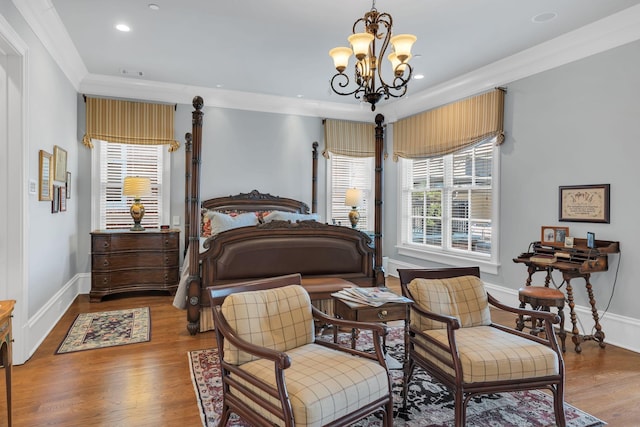 bedroom featuring baseboards, a notable chandelier, wood finished floors, and crown molding