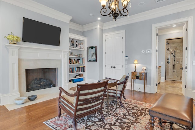 interior space with a premium fireplace, visible vents, wood finished floors, and crown molding