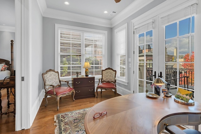 interior space featuring crown molding, wood finished floors, visible vents, and baseboards