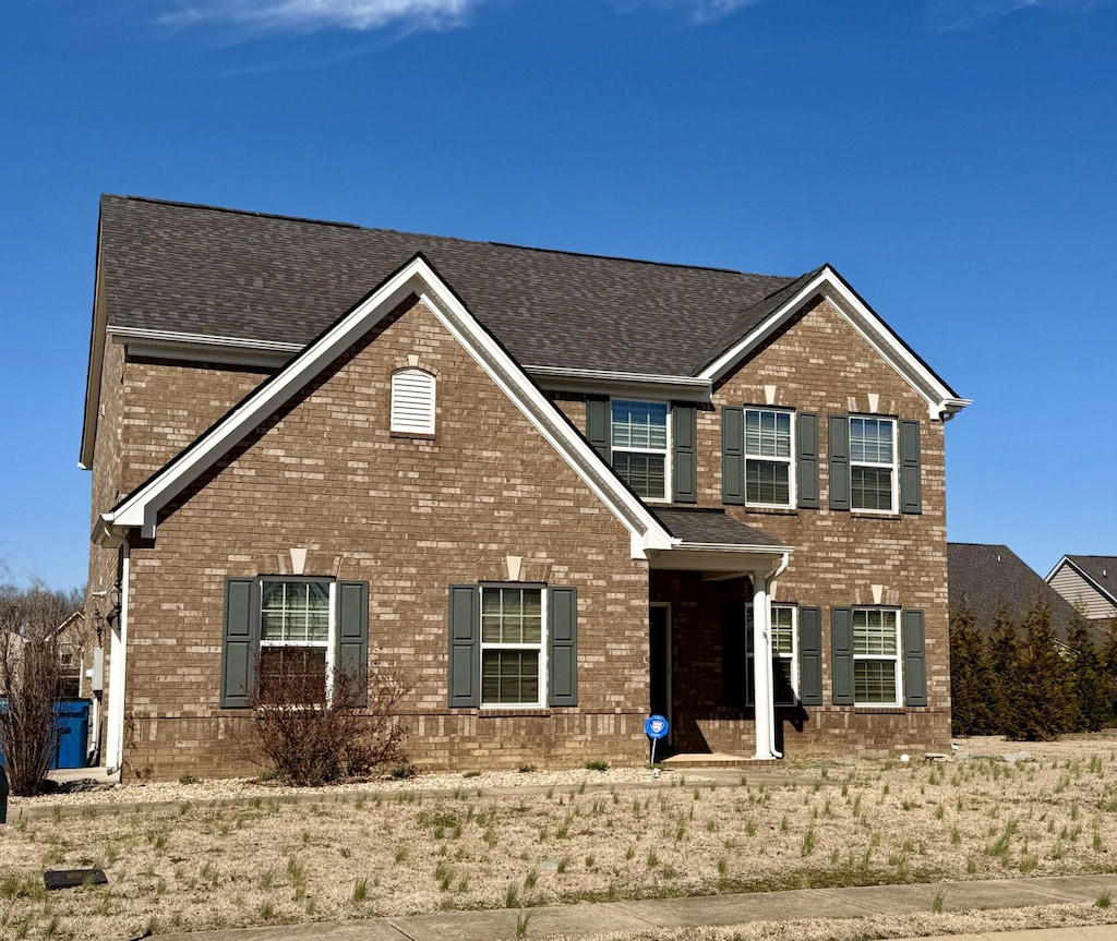 view of front of property featuring brick siding and a shingled roof