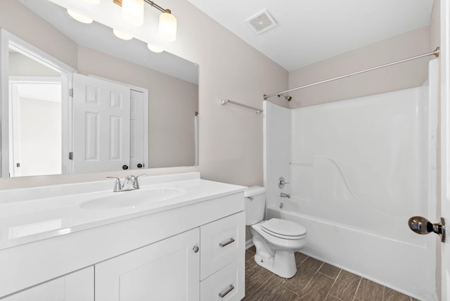 full bathroom featuring visible vents, wood tiled floor, toilet, shower / bath combination, and vanity