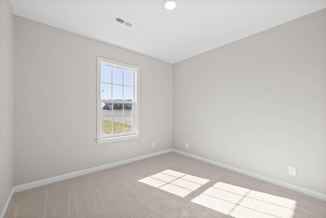 empty room with baseboards, visible vents, and carpet floors