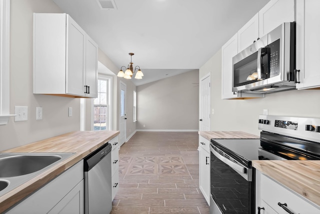 kitchen with white cabinetry, visible vents, wooden counters, and stainless steel appliances