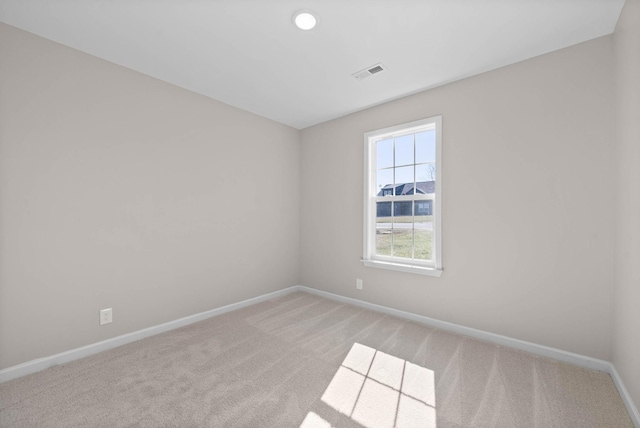 empty room with light carpet, visible vents, and baseboards