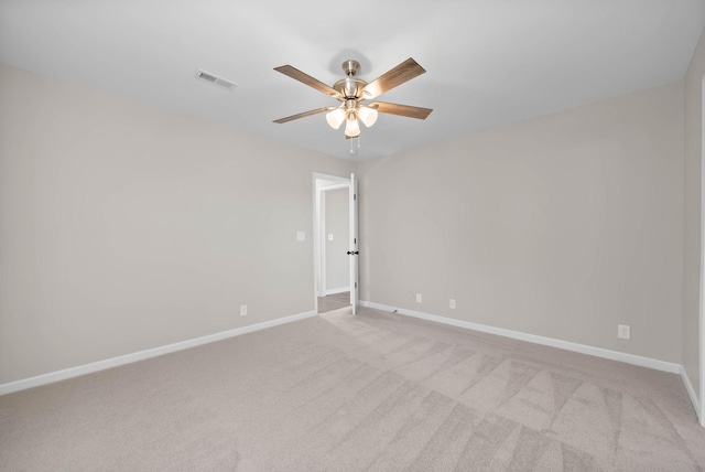 carpeted spare room featuring visible vents, baseboards, and a ceiling fan