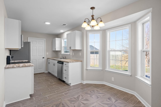 kitchen featuring a sink, white cabinets, light countertops, and stainless steel dishwasher