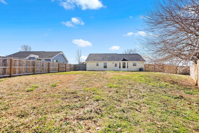 rear view of property with a lawn and a fenced backyard