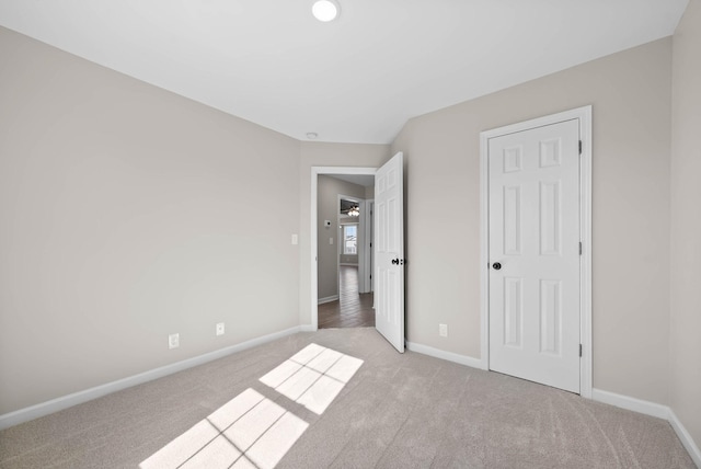 unfurnished bedroom with light carpet and baseboards