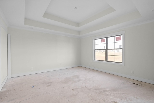 empty room with a raised ceiling and baseboards