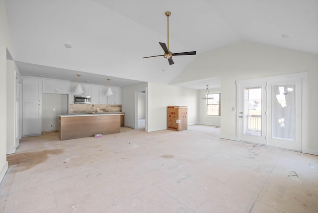 unfurnished living room with a sink, high vaulted ceiling, and a ceiling fan