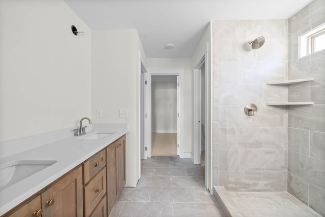 full bath with double vanity, tiled shower, and a sink